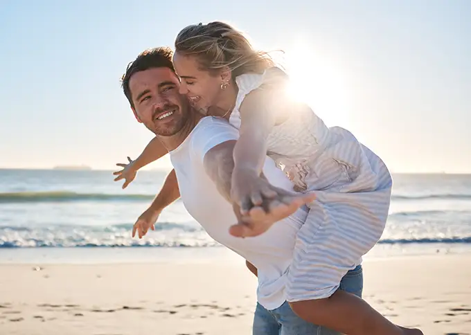 Una coppia felice passeggia sulla spiaggia, per amore, viaggio o vacanze estive.